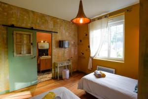 a small room with two beds and a window at L'EN VERT in Bagnères-de-Bigorre