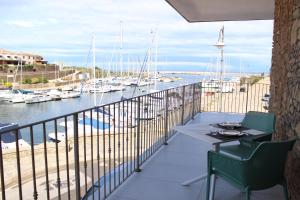 a balcony with a table and chairs and a marina at 103 Boutique Hotel Stintino in Stintino