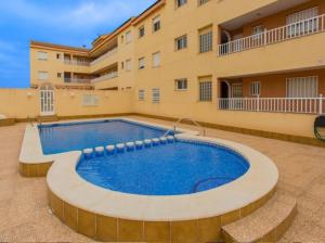 a swimming pool in front of a building at APARTAMENTO D&L CON ENCANTO- EN LOS ALCÀZARES-Totalmente equipado in Los Alcázares