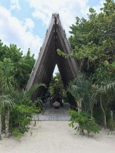a triangle shaped building with trees and a beach at Hotel Poc Na Tulum in Tulum