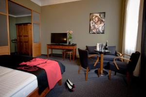 a hotel room with a bed and a table and a television at Hotel Havel in Rychnov nad Kněžnou