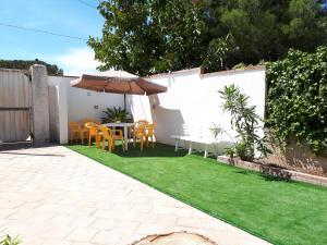 a patio with a table and chairs and an umbrella at Sun & Sea, holidays home in Fontane Bianche