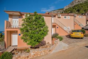 un coche amarillo estacionado frente a una casa en Apartment Mare, en Komiža