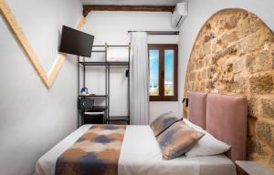 a bedroom with a bed and a wall with a window at Casa De La Sera in Rhodes Town