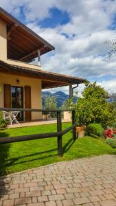 una cerca frente a una casa con montañas en el fondo en Appartamenti Il Medeghino, en Musso