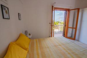 a bedroom with a bed and a door to a balcony at Sun & Sea, holidays home in Fontane Bianche