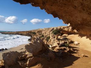 a view of a beach with rocks and the ocean at Roses Studios in Karpathos