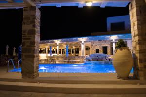 a swimming pool at night with a building at Sunset View Hotel in Parikia