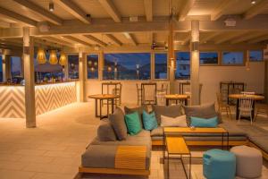 a living room with a couch and tables and chairs at Sunset View Hotel in Parikia