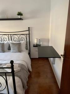 Un dormitorio con una cama con una mesa al lado. en Al Casa Paquito, en Almograve
