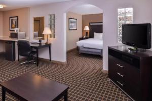 Una habitación de hotel con una cama y un escritorio con televisión. en Hotel Nova SFO, en South San Francisco