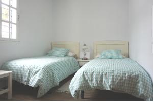 A bed or beds in a room at Adosado en playa de la Barrosa, casa Carlota