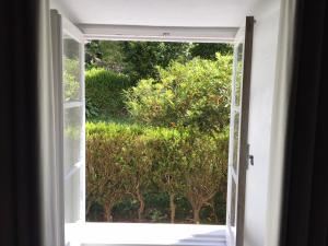 an open door to a garden with trees outside at Quinta das Rosas in Capelas