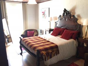 a bedroom with a large bed with red pillows at Quinta das Rosas in Capelas