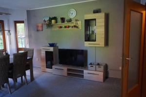 a living room with a flat screen tv and a table at Ferienwohnung Familie Neugebauer in Bruchhausen-Vilsen +12 photos