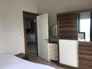 een slaapkamer met een wit bed en een grote spiegel bij Medıkule (7) 1+1 in Istanbul
