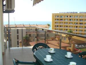 einen Tisch und Stühle auf einem Balkon mit Blick auf ein Hotel in der Unterkunft Alpen1 Paseo Marítimo in Peñíscola