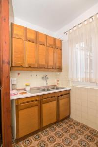 a kitchen with wooden cabinets and a sink at Apartment Grgo in Vodice