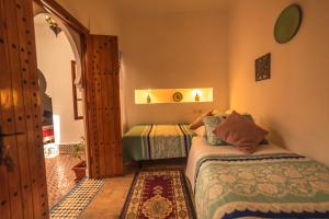 um pequeno quarto com 2 camas e uma porta em Riad Dari em Tétouan