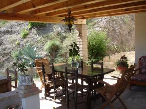 mesa de comedor y sillas bajo una pérgola de madera en Ca l' Ermitanyo- Casa Torre Blanca, en Súria