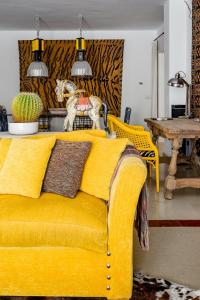 マルベーリャにあるChambao Suite Marbellaのリビングルーム(テーブル付)の黄色いソファ