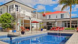 a house with a swimming pool in front of a house at Commodores Lodge in Russell