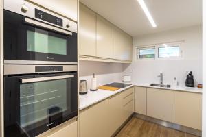 uma cozinha com armários brancos e electrodomésticos pretos em Victory Village 3B em Quinta do Lago