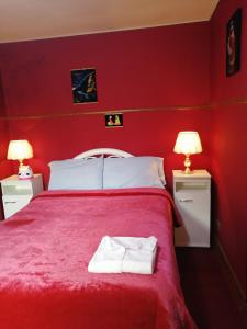 a red bedroom with a bed with two lamps at Gran Copacabana Hostal in La Paz