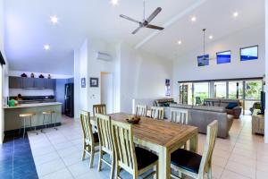 a kitchen and living room with a wooden table and chairs at Cooinda Gardens on Hamilton Island by HIHA in Hamilton Island