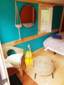 um quarto com uma cama e um espelho na parede em New Buddha Bing Unique Experience Cottage and Cabins em Tobermory