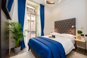 - une chambre avec un grand lit et des rideaux bleus dans l'établissement Villa Brandestini, à Pula