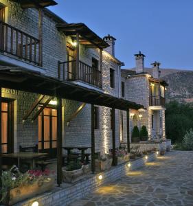 a house with lights on the side of it at Arkefthos Mountain Hotel in Papingo