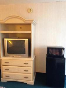 un centro de entretenimiento con TV y tocador en Royal Inn Columbia/Fort Jackson en Columbia