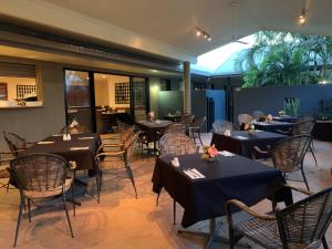 un restaurante con mesas y sillas en una habitación en Biloela Palms Motor Inn, en Biloela