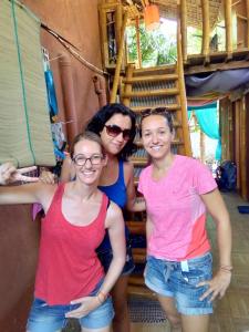 drei Frauen stehen nebeneinander vor einer Treppe in der Unterkunft Darpins Guesthouse in Dauin