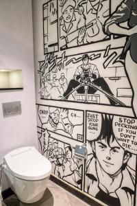 une salle de bains avec un mur recouvert de graffitis dans l'établissement Posto Dormire Hotel, à Jakarta