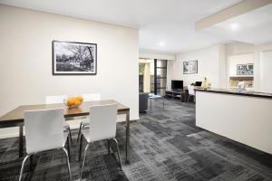 a kitchen and dining room with a table and chairs at Quest Narre Warren in Narre Warren
