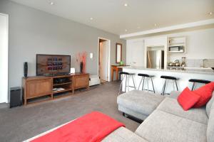 a living room with a couch and a kitchen at QV 2 Bedrooms Apartment Overlooking Marina -680 in Auckland