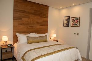 a bedroom with a large bed with a wooden headboard at Hotel Verticca in Santa Cruz Tecamac