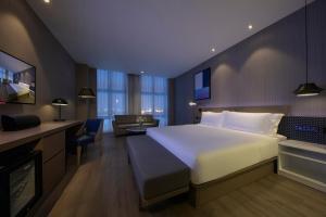 a bedroom with a large bed and a living room at Orange hotel select (shanghai pudong Airport Hotel) in Shanghai