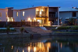 een huis met een meer ervoor bij Marina Views Townhouse in Darwin