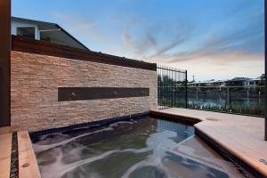 a swimming pool in front of a brick building at Marina Views Townhouse in Darwin