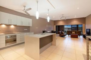 a kitchen and living room with a table and a couch at Marina Views Townhouse in Darwin