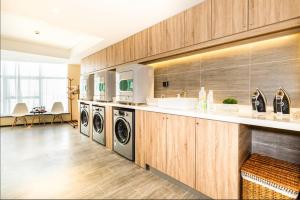 a laundry room with two washer and dryer at Atour Jiaozhou Qingdao Hotel in Qingdao