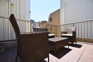 a balcony with chairs and tables on a balcony at TERRACE HOUSE Shibuya Maruyamacho in Tokyo