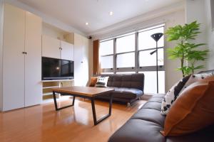 a living room with a couch and a table at TERRACE HOUSE Shibuya Maruyamacho in Tokyo