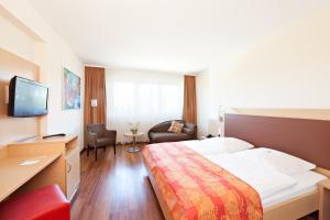 um quarto de hotel com uma cama e uma televisão em Hotel Imperial Dusseldorf - Sure Collection by BW em Dusseldorf