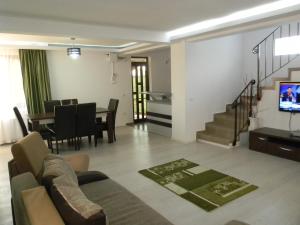 a living room with a couch and a dining room at Vila Verda in Eforie Nord