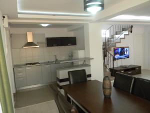 a kitchen and dining room with a table and a television at Vila Verda in Eforie Nord