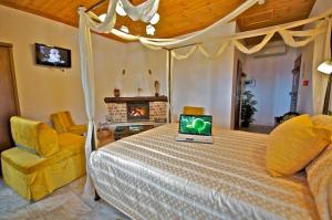 een slaapkamer met een bed met een laptop erop bij Archontiko Papoutsi in Mouresi